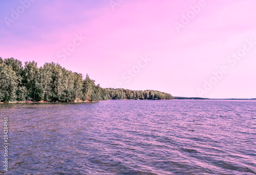 Most beautiful purple sunset on Lake Uvildy, Southern Urals (Chelyabinsk region, Russia). Lake and forest. Pink sunset is reflected in the water. The main fashion color of 2022. photo