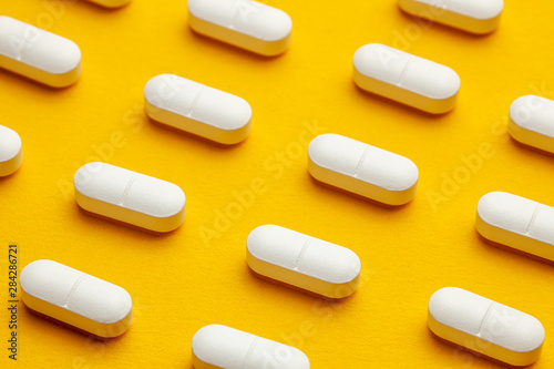 White pills on yellow background.