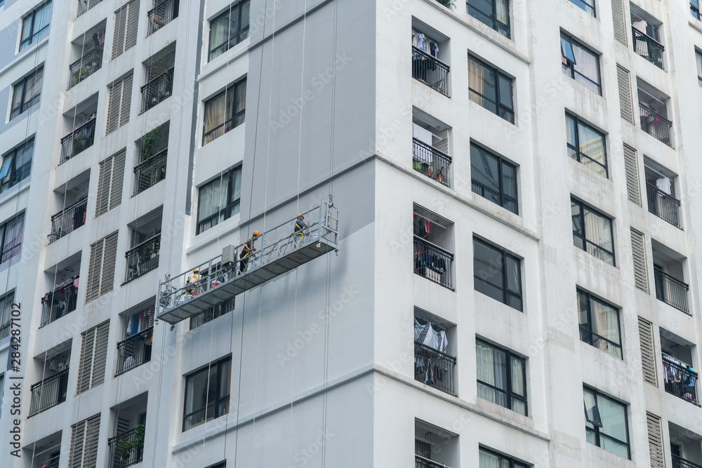 Apartment building with a group of worker painting building exterior