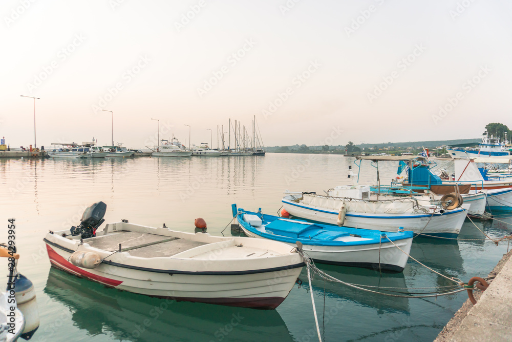 Small amateur fishing boats at pier with calm water