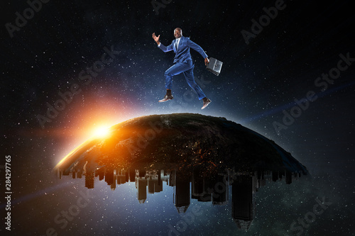 Black businessman running on the Globe with city buildings on the starry space background