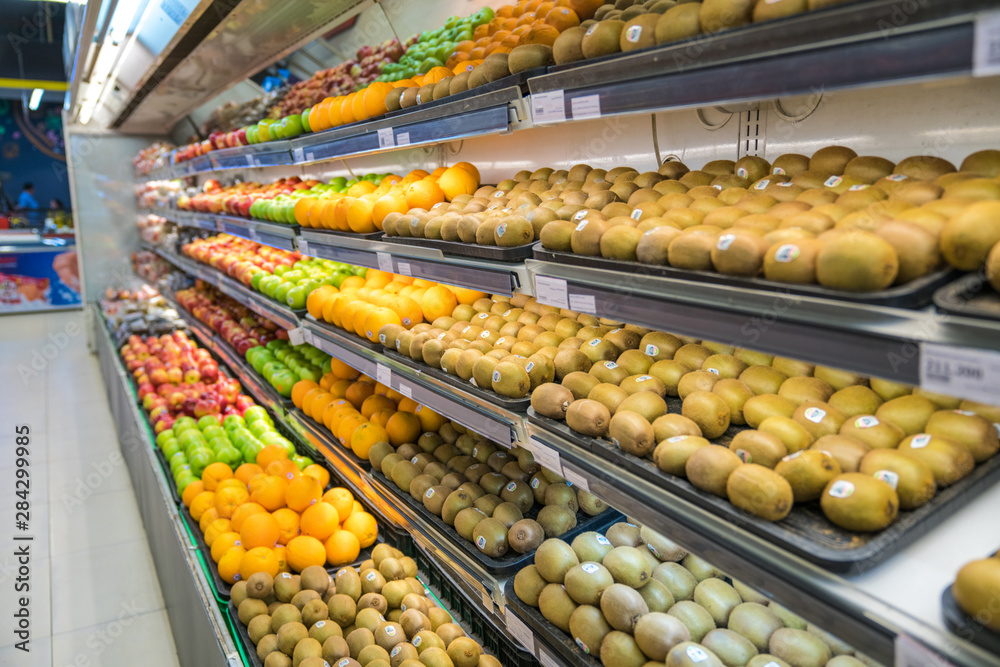 Fresh healthy fruits on shelves in supermarket