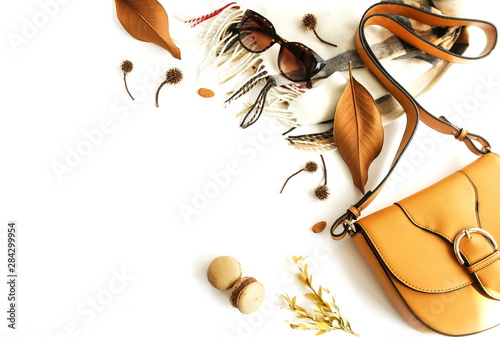 Autumn composition with women fashion  accessories top view on white background toned. Flat lay collage of female style look with bag, sunglasses, scarf, notebook mock up, autumn leaves. Copy space