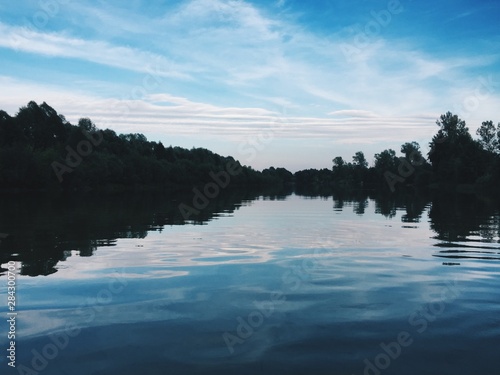Fototapeta Naklejka Na Ścianę i Meble -  Beautiful blue river with reflecting clouds in the water in the middle of green forests with trees Processed with VSCO with hb2 preset
