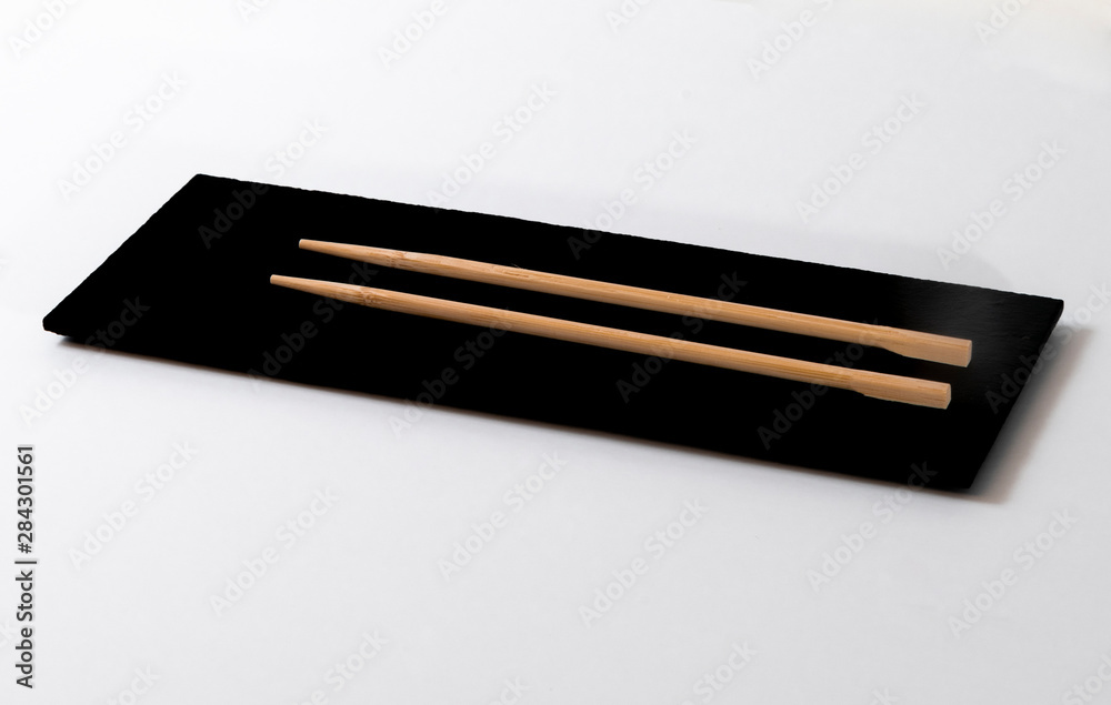 Top view of a pair of chopsticks on a black stone table Top view of a pair of chopsticks on a black stone table