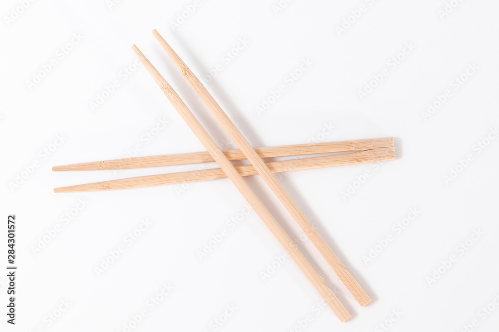Four chopsticks made of wood insulated on a white background.