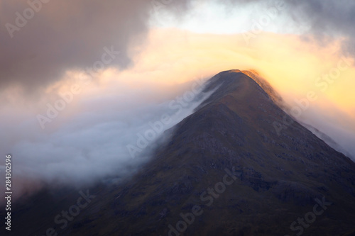 Morning light kissing mountain peak during sunrise in Scottish Highlands. © Jazzlove