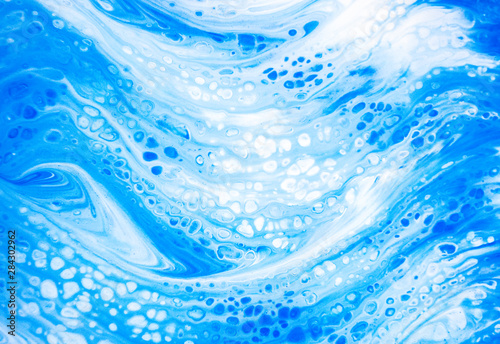 Abstract colorful painting background made in fluid art technique. Trendy pattern in blue and white colors.