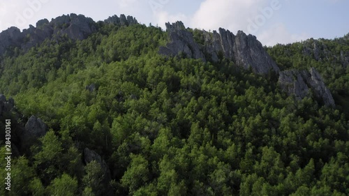 aerial view of ural nature. drone flying over the steep stony slope with coniferous and deciduous mixed forest at the foot of mountain. natiounal park, ecological protected area in Russia