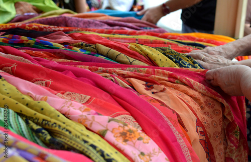 pile of colorful fabrics hands choosing