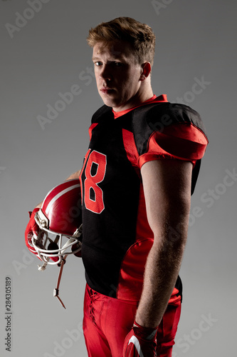 American football player standing with helmet