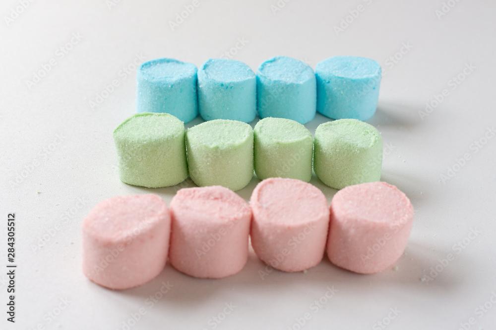 Rows of colored marshmallows on a white table. Marshmallow figures. Rows of colored marshmallows on a white table. Marshmallow figures.