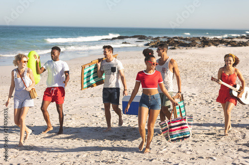 Group of friends walking together on the beach