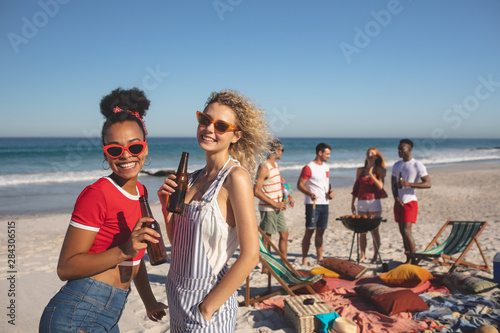 Group of female friends having beer on the beach