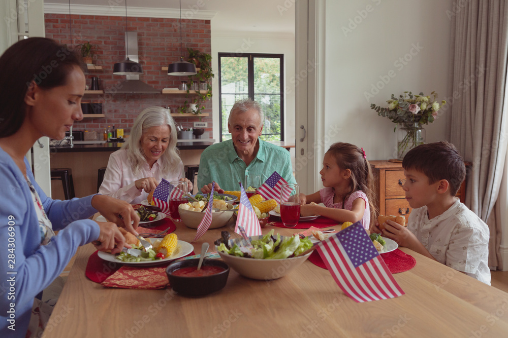 Multi-generation family having food on dining table at home Multi-generation family having food on dining table at home