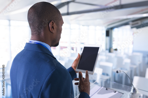 Male speaker practicing his speech on digital tablet in business seminar