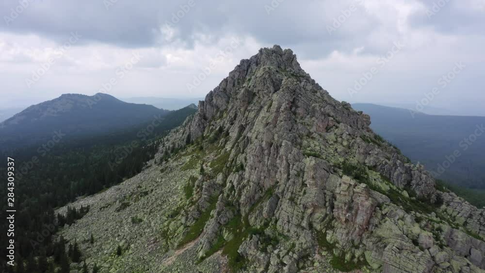 aerial view of ural nature. drone flying over the steep stony slope with coniferous and deciduous mixed forest at the foot of mountain. natiounal park, ecological protected area in Russia aerial view of ural nature. drone flying over the steep stony slope with coniferous and deciduous mixed forest at the foot of mountain. natiounal park, ecological protected area in Russia