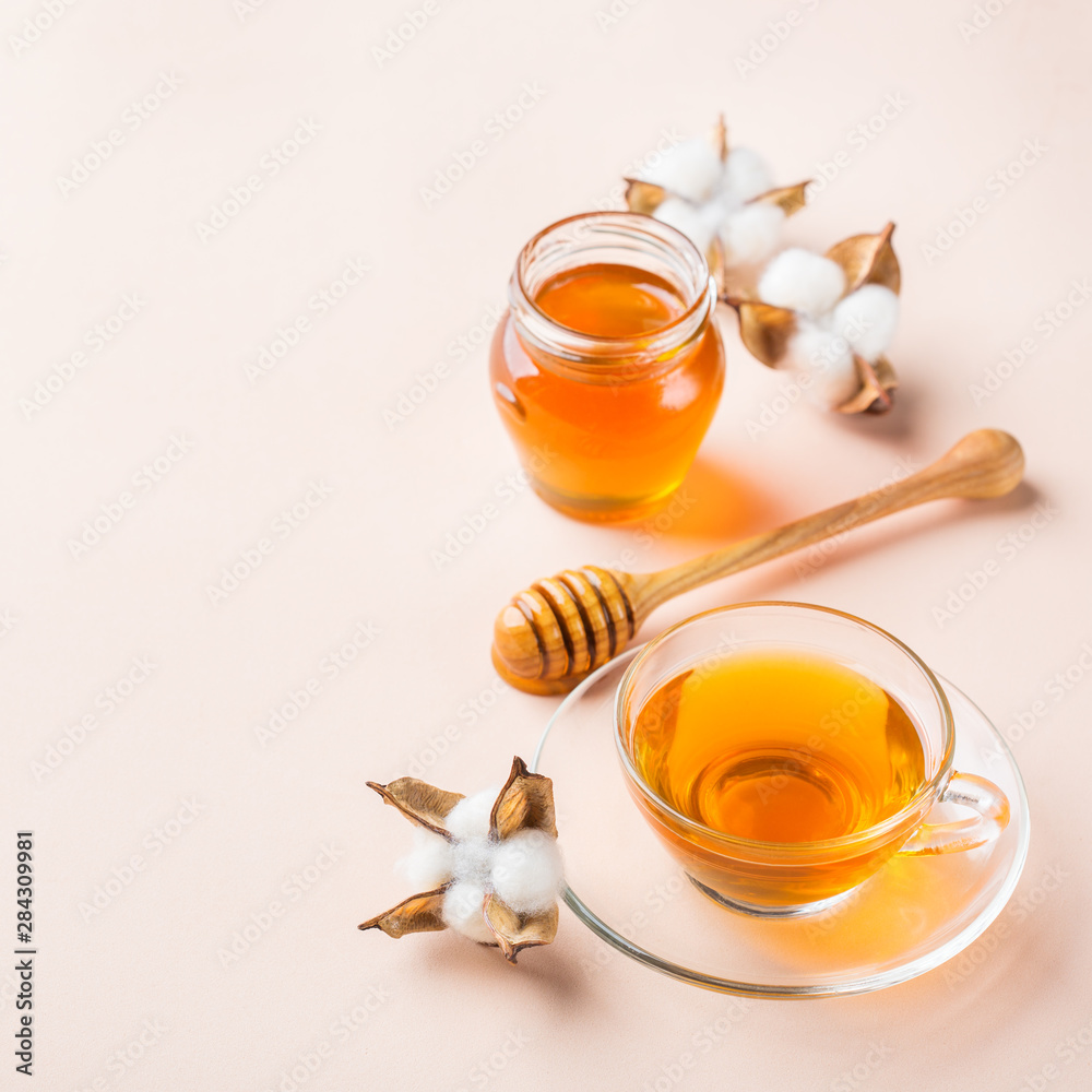 Cup of tea with honey on pastel pink, apricot background Cup of tea with honey on pastel pink, apricot background