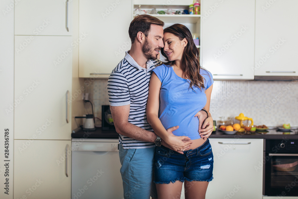 Pregnant woman with husband in the kitchen Pregnant woman with husband in the kitchen