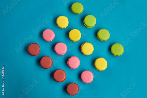 Colored macaron or macaroon  sweet meringue-based confection on blue background. Close-up  copy space.