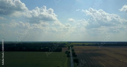 bird view of rural road between fields. 4K aerial footage of a car riding on a road photo