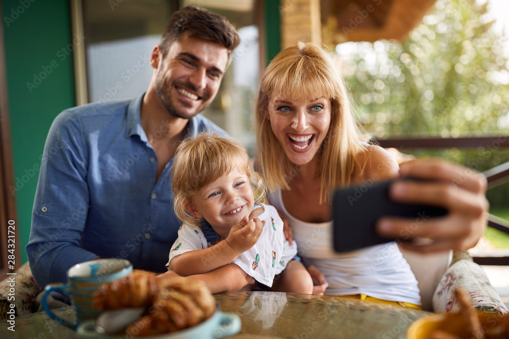 Cheerful family making selfie together