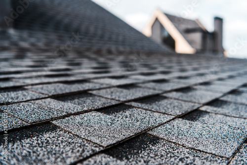 selective focus of grey shingles on rooftop of building photo