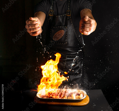 Cook sprinkles lemon juice on flambe meat photo