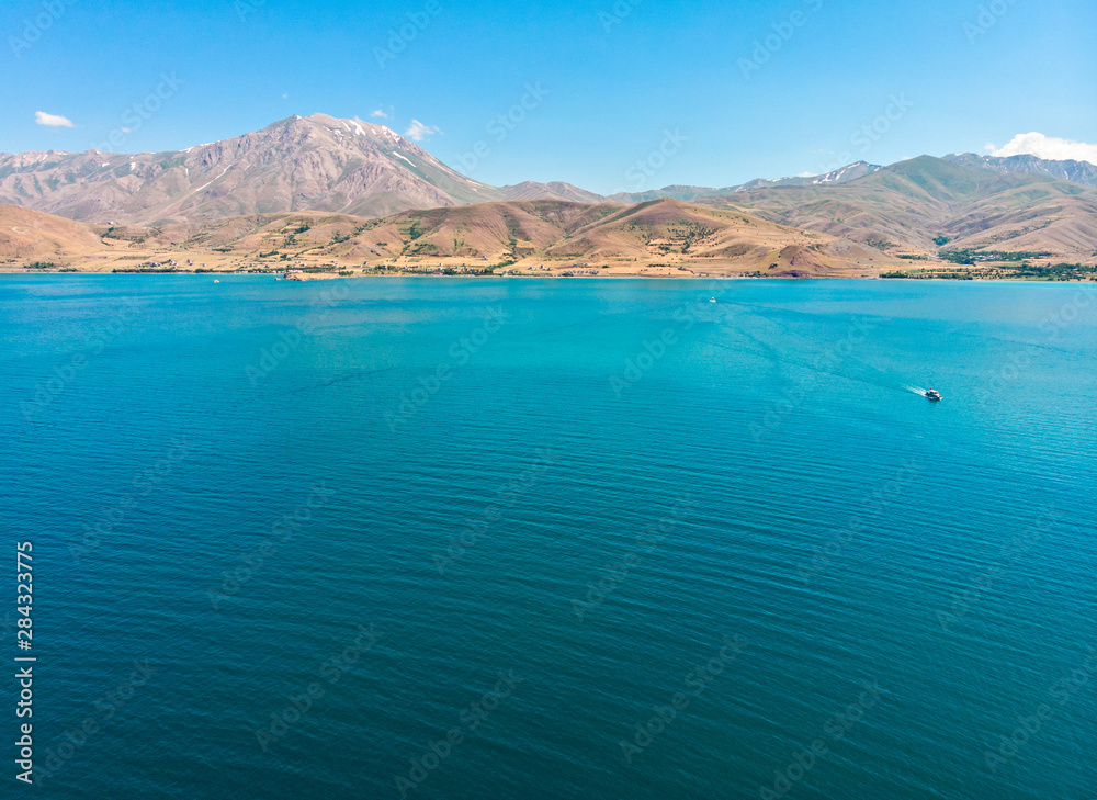 Aerial view of Lake Van the largest lake in Turkey, lies in the far east of that country in the provinces of Van and Bitlis. Crystal and clear waters. Mountains and clouds in the background