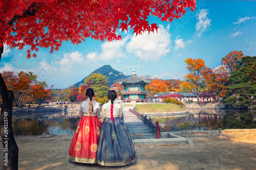 young woman with umbrella in autumn park Gyeongbokgung palace, Hyangwonjeong Pavilion, in autumn Seoul,South Korea. photo