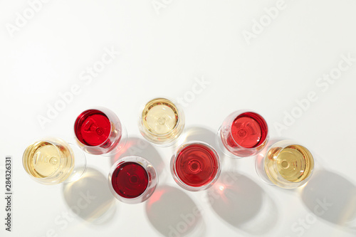 Flat lay composition. Glasses with different wine on white background, top view