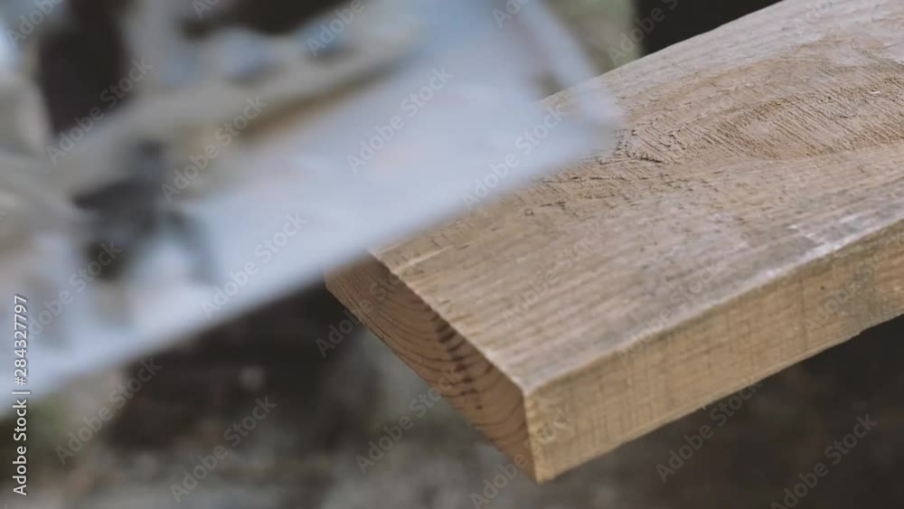 Hand man sawed wooden board using a miter saw. Chop saw. Hand man sawed wooden board using a miter saw. Chop saw.