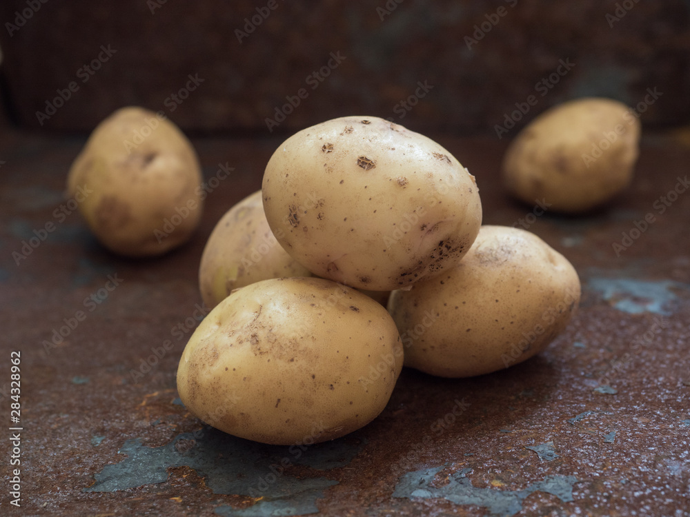 Fresh, ugly yellow potatoes on a rusty iron background. Close up Fresh, ugly yellow potatoes on a rusty iron background. Close up