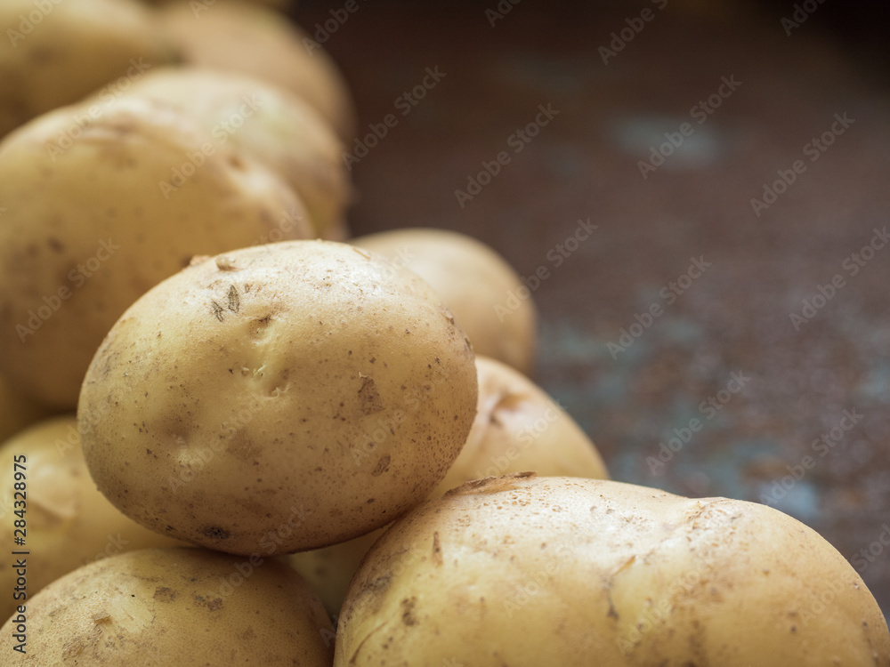 Fresh, ugly yellow potatoes on a rusty iron background. Close up Fresh, ugly yellow potatoes on a rusty iron background. Close up