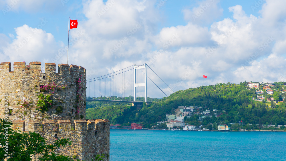 Fototapeta premium Rumelian Fortress and Bosphorus Bridge in İstanbul, Turkeyç Turquoise sea and cloud sky.