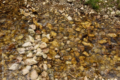 Close up of a flowing water (stream) in the forest. Top view.