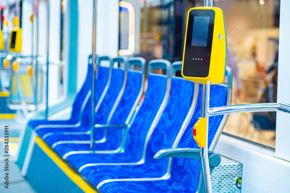 Validator on the bus handrail. Fare control without a conductor. Non-cash transport payment. Terminal of payment for travel by transport or bank cards. Public city passenger transport.