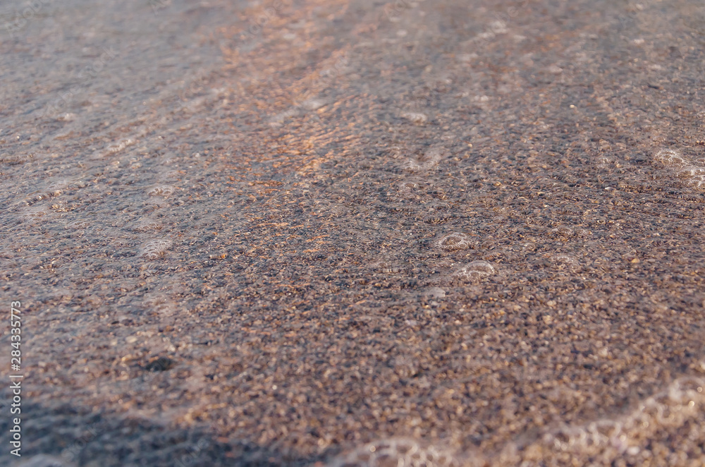 Closeup of sandy beach with soft incoming waves. Selective focus Closeup of sandy beach with soft incoming waves. Selective focus