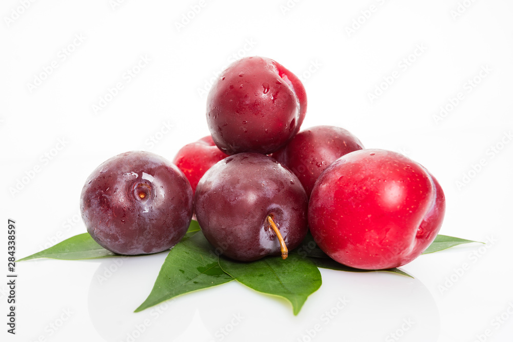 plums with plum leaves on a white background