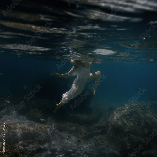 Woman in white swims underwater in the sea © Dmitry