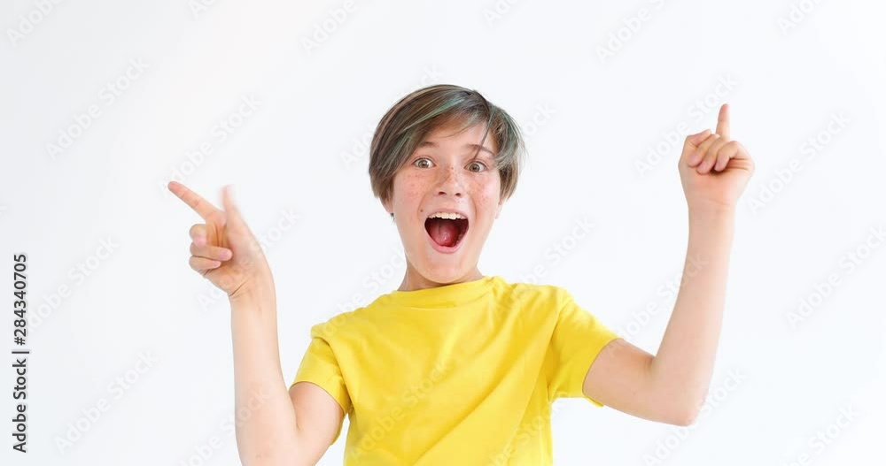 Positive teenager smiles and waves his hand. Beauty. Childhood. Emotions. Positive teenager smiles and waves his hand. Beauty. Childhood. Emotions.