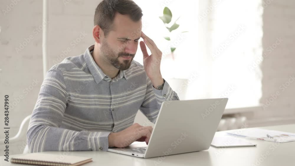 Distraught Adult Man with Headache at Work Distraught Adult Man with Headache at Work