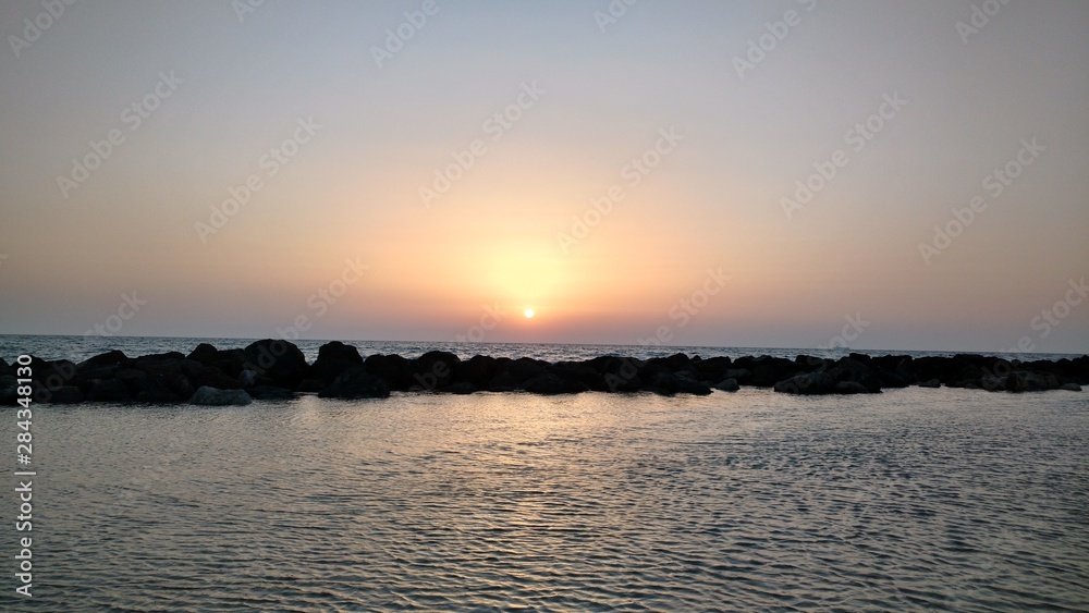 Sunset in the Mediterranean sea seen from Haifa's beach promenade, in Israel.