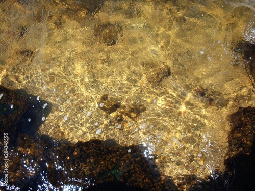 Large round stones at the bottom of the lake in clear, clear water.