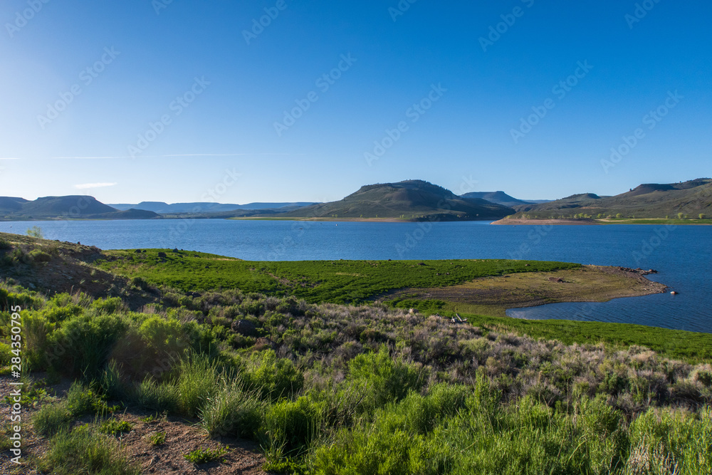 Landscape of Blue Mesa Reservoir with greenery and hills in the background near Gunnison, Colorado