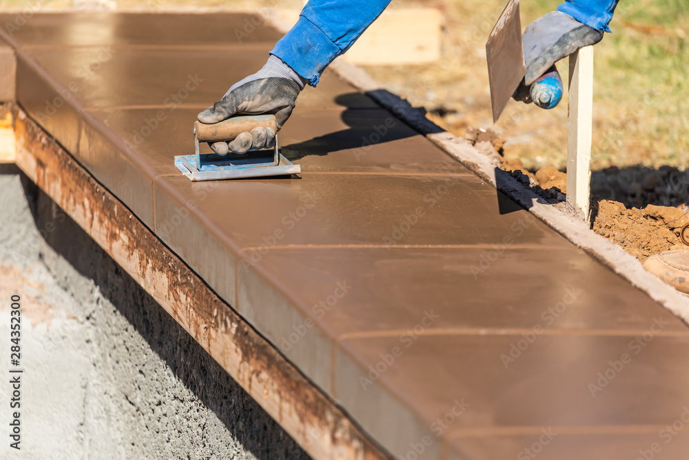 Construction Worker Using Hand Groover On Wet Cement Forming Coping Around New Pool Construction Worker Using Hand Groover On Wet Cement Forming Coping Around New Pool