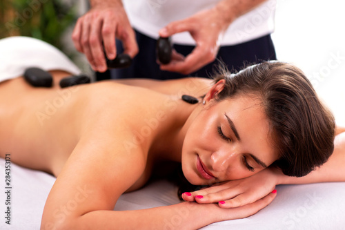 Pretty girl having a stone massage therapy