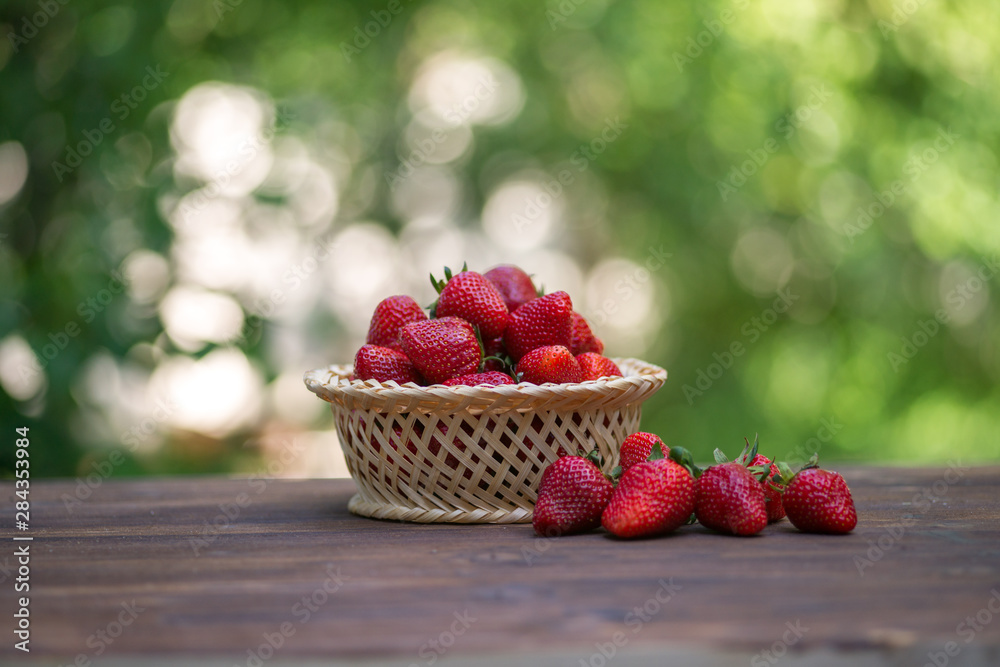 strawberries in a basket on a wooden background strawberries in a basket on a wooden background