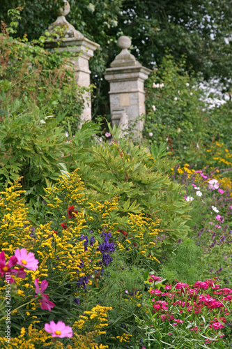 Herbaceous Flower Border with an Old Fashioned Walled Garden with Grand Stately Entrance
