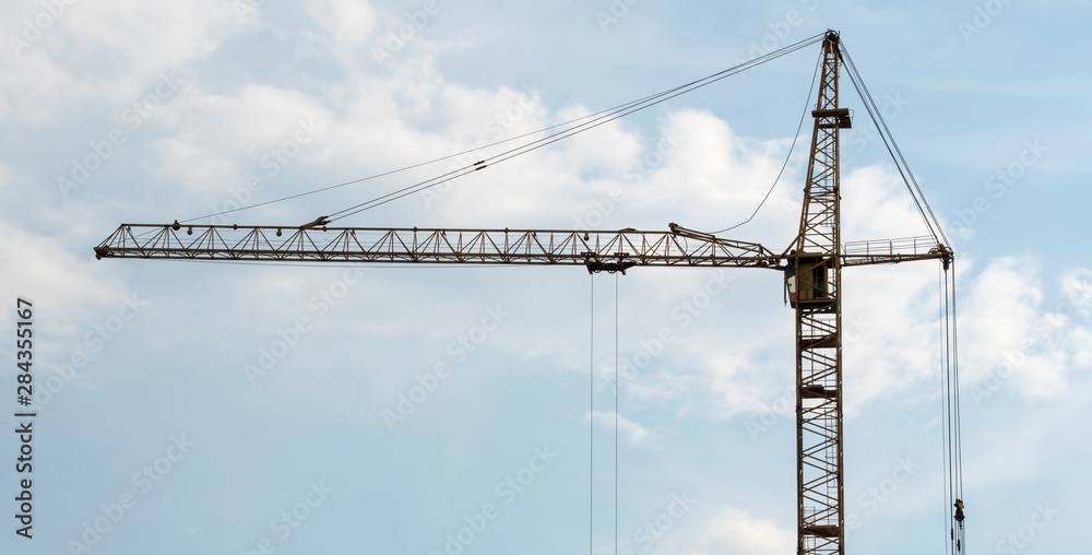 Tower crane on blue sky background on construction site. Tower crane on blue sky background on construction site.